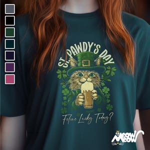 May include: A green t-shirt featuring a cartoon cat wearing a green hat and holding a beer. The text on the shirt reads "St. Pawdy's Day" and "Feline Lucky Today?"