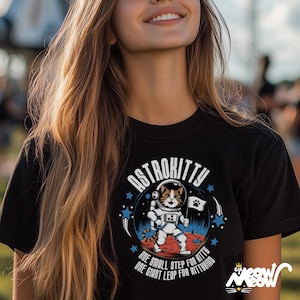May include: Black t-shirt with a graphic of a cat in a spacesuit on the moon. The graphic says "Astrokitty" and "One small step for kitty, one giant leap for kittykind".