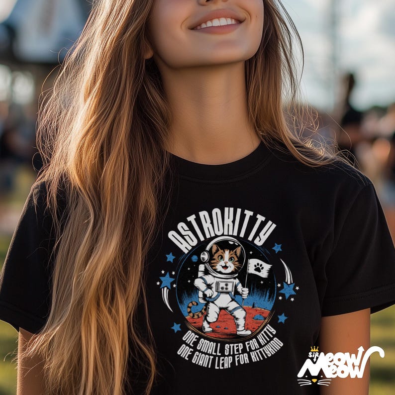 May include: Black t-shirt with a graphic of a cat in a spacesuit on the moon. The graphic says "Astrokitty" and "One small step for kitty, one giant leap for kittykind".