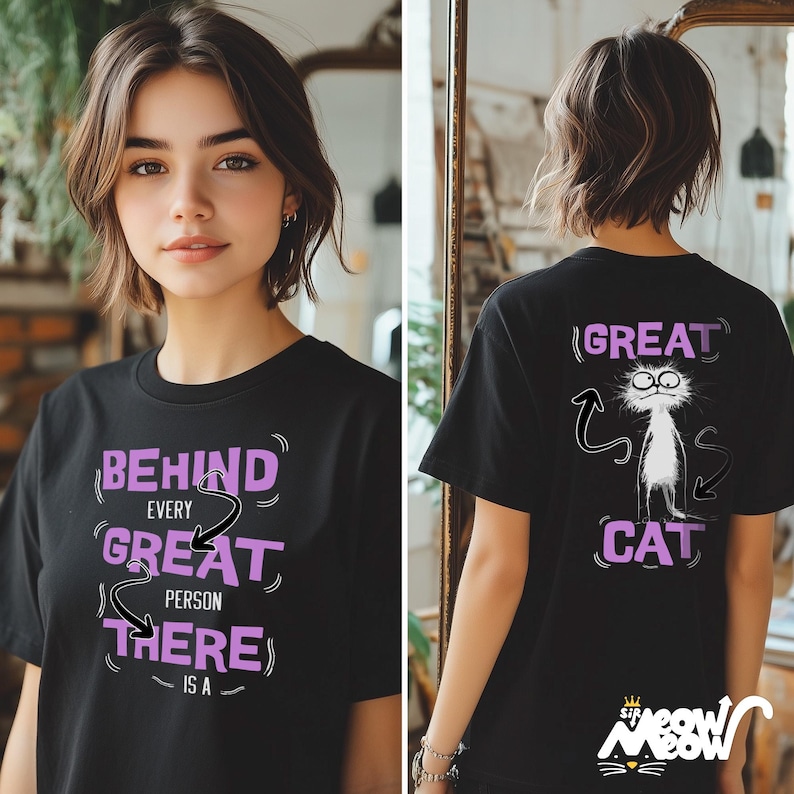 Puede incluir: Camiseta negra con un gr&aacute;fico morado que dice "Behind every great person there is a great cat". La parte posterior de la camiseta tiene un gato de dibujos animados con el texto "Great Cat" en morado.