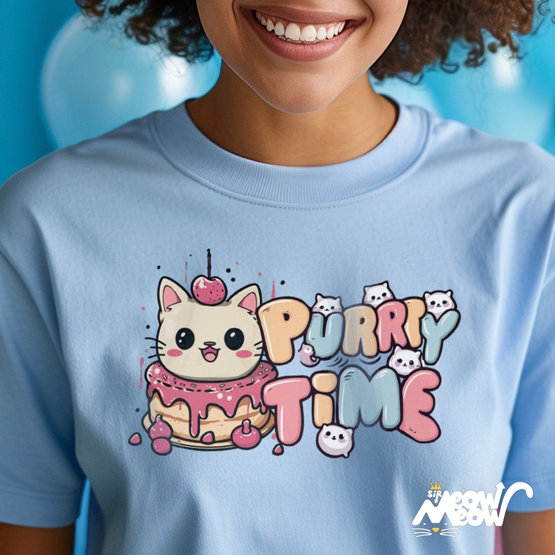 K&ouml;nnte beinhalten: Ein hellblaues T-Shirt mit einer Comic-Katze, die einen rosa-wei&szlig;en Kuchenhut tr&auml;gt. Der Text "Purrry Time" ist in einer bunten Schrift mit kleineren Comic-Katzen um den Text herum geschrieben. Der untere Teil des Shirts tr&auml;gt den Text "Sir Meow Meow" in einer schwarz-wei&szlig;en Schrift.