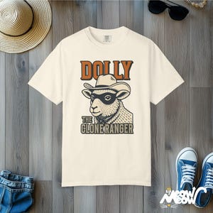 Camiseta de Dolly la Ranger Clonada: Divertida camiseta con estampado de oveja vaquera y colores cómodos. Ivory