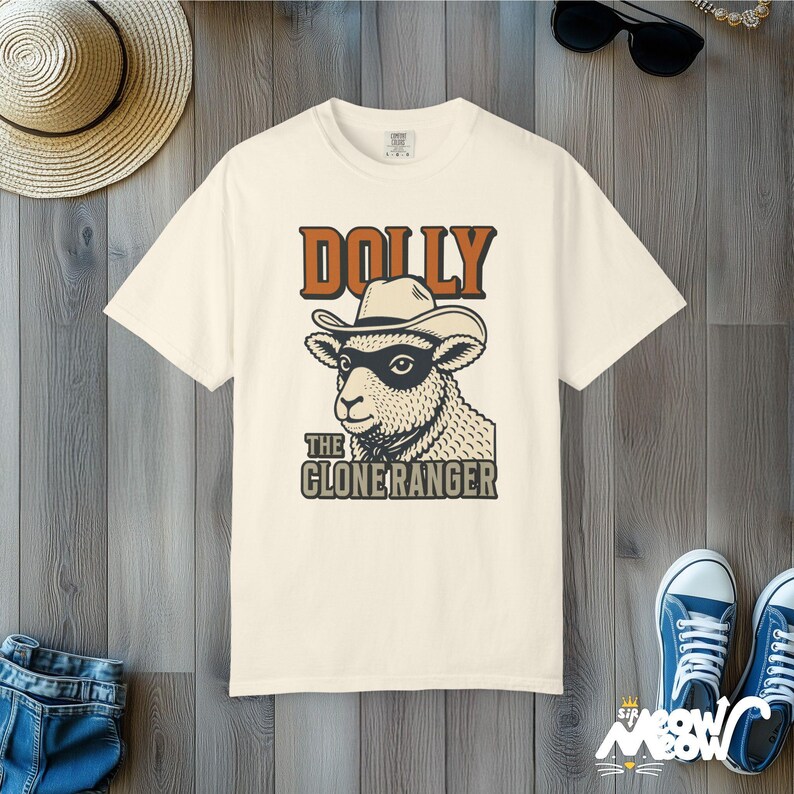 Camiseta de Dolly la Ranger Clonada: Divertida camiseta con estampado de oveja vaquera y colores cómodos. Ivory