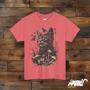 Vintage style t-shirt print of a cat in the woodlands surrounded by wildflowers, mushrooms and butterflies. Salmon tee.