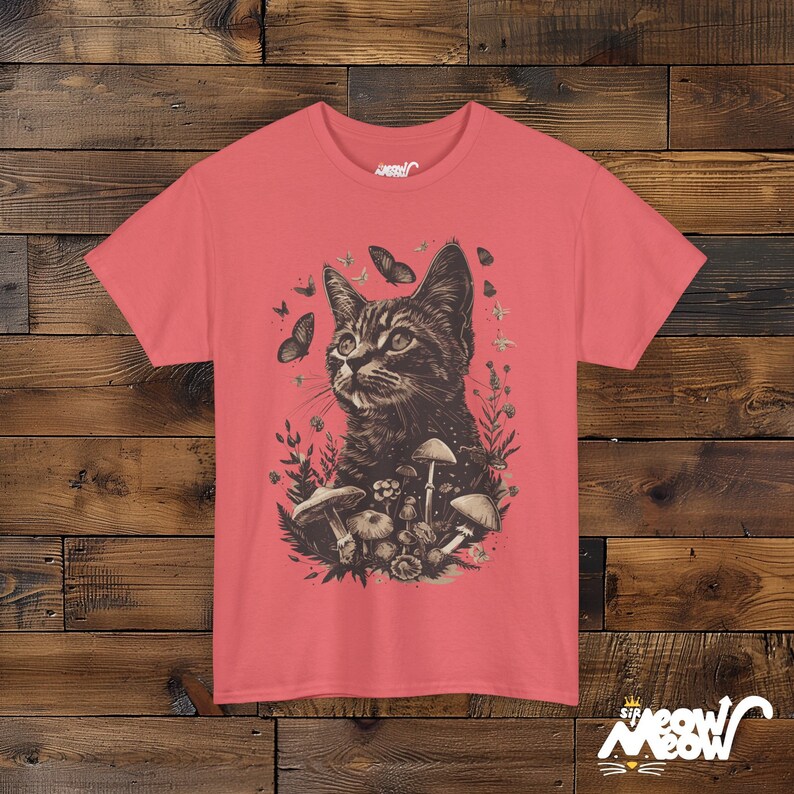 Vintage style t-shirt print of a cat in the woodlands surrounded by wildflowers, mushrooms and butterflies. Salmon tee.