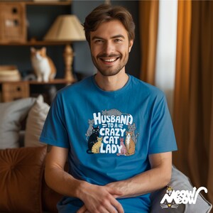 Może przedstawiać: Niebieska koszulka z nadrukiem kot&oacute;w i tekstem "Husband to a Crazy Cat Lady".