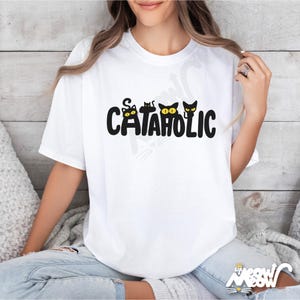 Pu&ograve; includere: T-shirt bianco con la scritta "CATAHOLIC" in nero, con tre sagome di gatti neri con occhi gialli. La maglietta &egrave; di uno stile casual e confortevole.