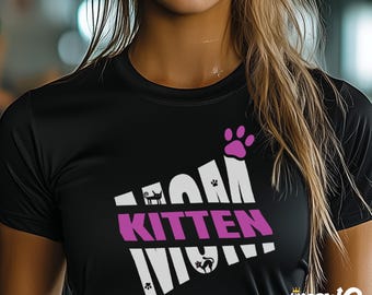Peut inclure: T-shirt noir avec un motif blanc qui dit "Mom Kitten Mom" avec une empreinte de patte rose et un "Kitten" rose au milieu.