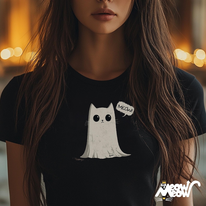 May include: A black t-shirt with a white ghost cat wearing a white ghost sheet and a speech bubble that says "MEOW!"