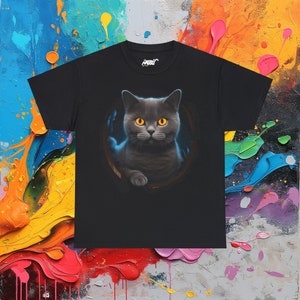 May include: Black t-shirt with a graphic of a gray cat with yellow eyes peeking out of a hole. The cat has a serious expression and is looking directly at the viewer.