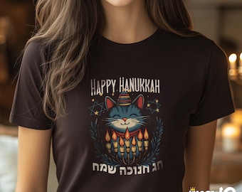 May include: A black t-shirt with a graphic of a cat wearing a hat and holding a menorah. The text "Happy Hanukkah" and Hebrew text are printed on the shirt.