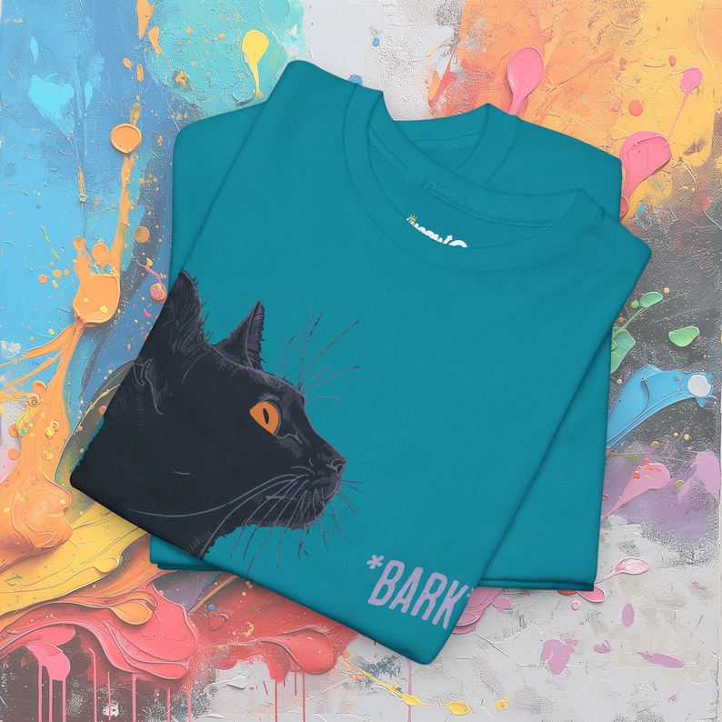May include: A teal blue t-shirt with a black cat illustration and the text "#BARK" printed on the front.