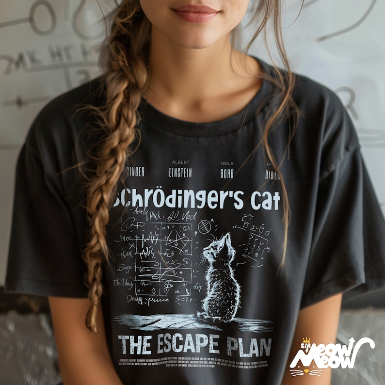 May include: Black t-shirt with a white graphic print of a cat looking up at a chalkboard with equations and the text "Schr&ouml;dinger's cat" and "The Escape Plan".