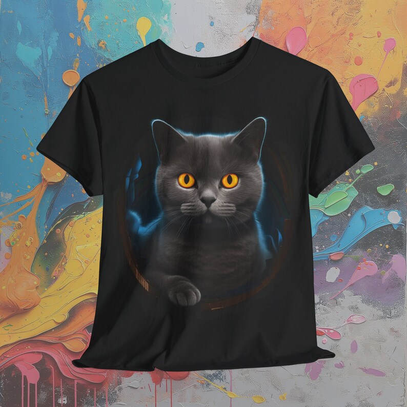 May include: Black t-shirt with a graphic of a gray cat with bright orange eyes peering out of a circle.