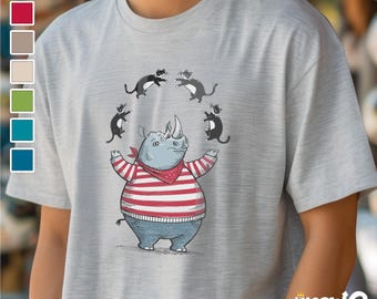 Può includere: Una maglietta grigia con un'illustrazione di un rinoceronte in stile cartone animato che indossa una camicia a righe rosse e bianche e un bandana rosso. Quattro gatti neri saltano intorno al rinoceronte.