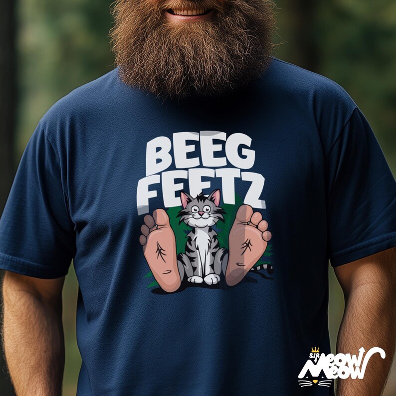 May include: A navy blue t-shirt with a cartoon cat sitting between two large feet. The text "BEEG FEETZ" is printed above the cat.