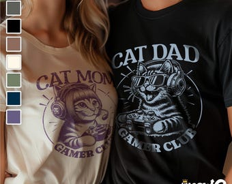 May include: A couple wearing matching t-shirts with a cat gamer design. The woman's shirt says "Cat Mom Gamer Club" and the man's shirt says "Cat Dad Gamer Club".
