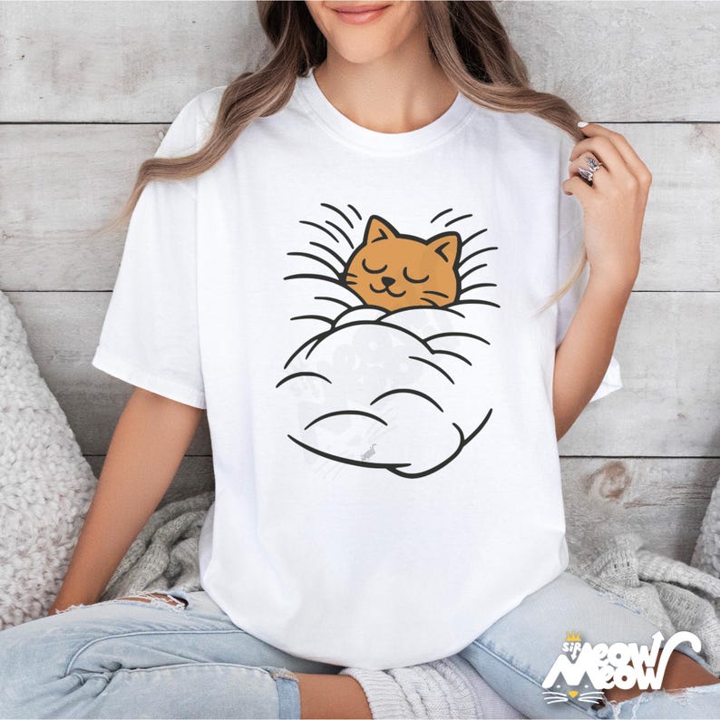 May include: White t-shirt featuring a cartoon cat sleeping in a cloud. The cat is orange with closed eyes, and the cloud is white with black outlines. The shirt has the text "Sip Meow Meow" at the bottom.