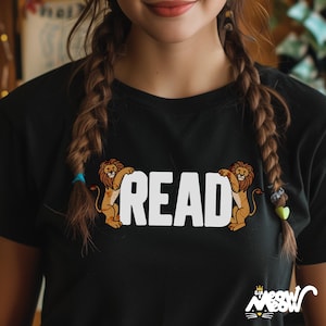 Könnte beinhalten: Schwarzes T-Shirt mit einer weißen Grafik von zwei Löwen, die das Wort "READ" hochhalten.