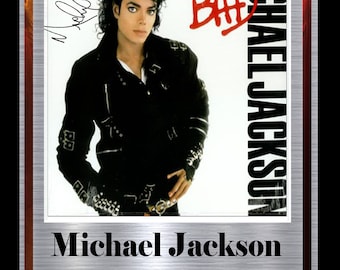 May include: A silver framed display featuring a signed Michael Jackson album cover. The album cover is white with the word "BAD" in red lettering. The album cover features a black and white photo of Michael Jackson wearing a black leather jacket. The display also includes the text "Michael Jackson Limited Edition Signed Display."