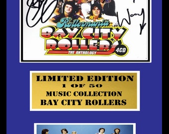 May include: A framed limited edition music collection of Bay City Rollers. The frame is gold with black text that reads "Limited Edition 1 of 50 Music Collection Bay City Rollers". The image inside the frame is a white background with a red, yellow, and blue logo that reads "Rollermania Bay City Rollers The Anthology 4CD". There are five signatures on the image.
