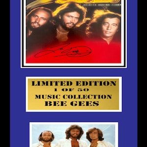 Könnte beinhalten: Ein gerahmtes Bee Gees-Albumcover mit einer goldenen Plakette mit der Aufschrift "Limited Edition 1 of 50 Music Collection Bee Gees". Das Albumcover zeigt einen roten Hintergrund mit den Bandmitgliedern in Schwarzweiß. Das Albumcover ist von der Band signiert.
