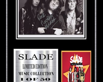 May include: Framed artwork featuring the band Slade. The top section is a black and white photo with signatures. Below, a silver plaque reads "SLADE LIMITED EDITION MUSIC COLLECTION 1 OF 50 STEREO SOUND." A red poster is on the right.