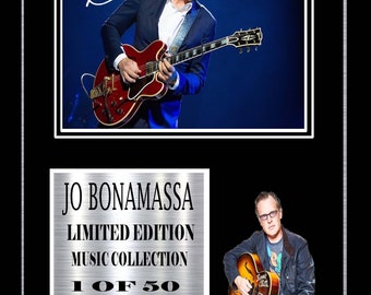 May include: A silver plaque with a black background and a photo of a man playing a guitar. The plaque reads "Jo Bonamassa Limited Edition Music Collection 1 of 50 Stereo Sound".