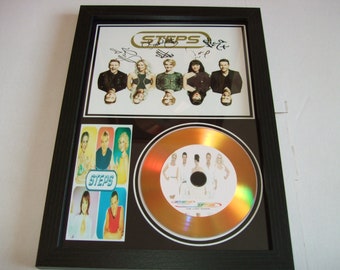 May include: A framed gold disc featuring a picture of the band Steps. The disc is signed by all five members of the band. The frame also includes a smaller picture of the band.