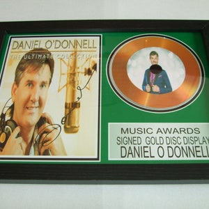May include: A framed gold record display with a photo of Daniel O'Donnell and the text "Music Awards Signed Gold Disc Display Daniel O'Donnell".