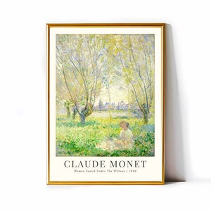 Puede incluir: Una impresión enmarcada de una pintura de Claude Monet titulada "Mujer sentada bajo los sauces" de 1880. La pintura representa a una mujer sentada en un campo de hierba verde bajo un sauce. El fondo muestra un pueblo con edificios y árboles.
