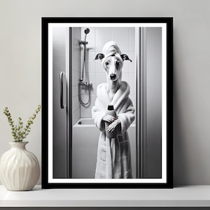 May include: A black and white photograph of a dog wearing a white bathrobe and a towel on its head. The dog is holding a bottle of shampoo in its paws and is standing in a bathroom.
