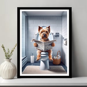 以下が含まれることがあります： 茶色とベージュの犬がバスルームの白いトイレに座って新聞を読んでいます。犬は白い首輪をしていて、茶色の鼻をしています。バスルームは白いタイルの壁と白いトイレの座席があります。