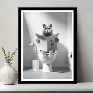 May include: A black and white photograph of a cat sitting on a toilet and reading a newspaper. The cat has a serious expression.
