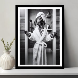 Könnte beinhalten: Ein Schwarzweißfoto eines Hundes, der einen weißen Bademantel und ein Handtuch auf dem Kopf trägt und in einer Duschkabine steht.