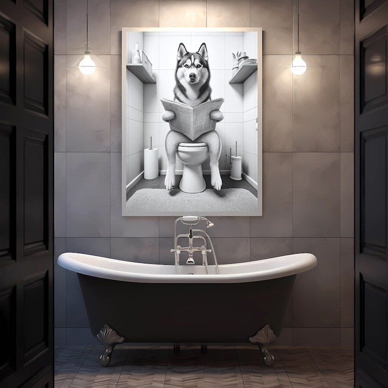 May include: A black and white photo of a husky dog sitting on a toilet and reading a newspaper. The photo is framed and hanging on a bathroom wall above a black bathtub.
