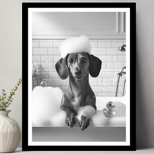 Op de afbeelding: Een zwart-witfoto van een teckel in bad met een rubberen eendje. De hond draagt een witte badmuts en heeft zeepschuim op zijn vacht.