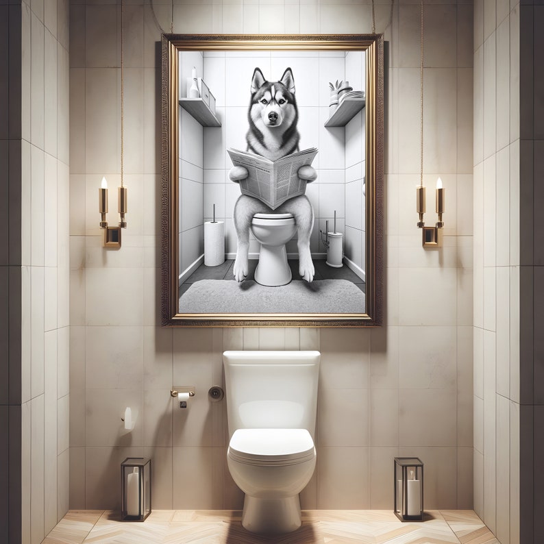 May include: A black and white photo of a husky dog sitting on a toilet and reading a newspaper. The photo is framed in gold and hanging on a wall in a bathroom.