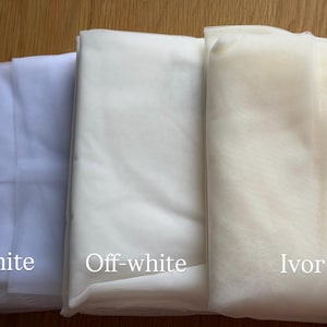 K&ouml;nnte beinhalten: Drei gefaltete Stoffe in Wei&szlig;, Off-White und Elfenbein. Die Stoffe sind mit ihren jeweiligen Farben beschriftet. Das Bild zeigt die verschiedenen Wei&szlig;t&ouml;ne, ideal f&uuml;r Braut- oder Bastelprojekte.