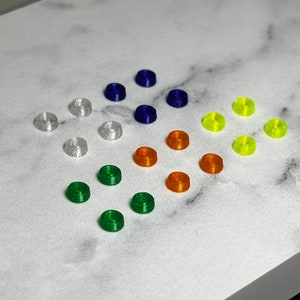 May include: Assortment of small, colorful, plastic rings. The rings are in shades of blue, white, orange, yellow, and green.