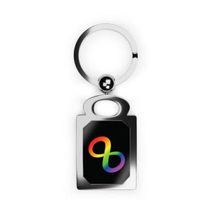 Puede incluir: Un llavero plateado con un colgante rectangular. El colgante tiene un fondo negro y un símbolo de infinito arcoíris. El llavero tiene un anillo circular y una pequeña cuenta decorativa.