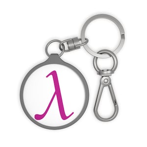 May include: A round keychain with a white background and a magenta lambda symbol. The keychain has a gray border and a silver clasp and key ring.