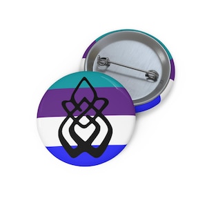 May include: A round pinback button featuring a horizontal striped background in teal, purple, white, and blue. Centered on the front is a black, symmetrical, abstract knot-like symbol. The back of the button shows a silver metal pin mechanism.