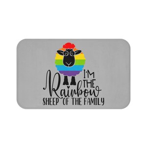 May include: A gray bath mat with a black sheep with a rainbow wool coat. The text "I'm the Rainbow Sheep of the Family" is printed on the mat.