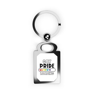 May include: Silver keychain with a rectangular tag that says "Gay Pride" with a rainbow progress bar that says "Loading" underneath.