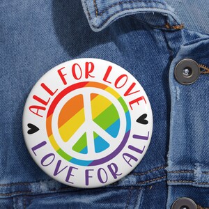 May include: A white button with a rainbow peace sign and the text "All for Love Love for All" in red.