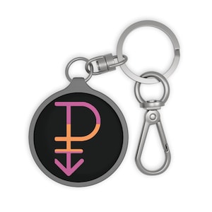 May include: A round black keychain with a silver metal clasp and key ring. The keychain features a colorful design with a pink, orange, and purple symbol.