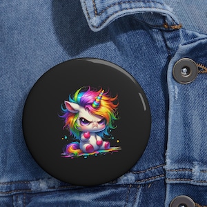 Könnte beinhalten: Ein schwarzer Button mit einem Cartoon-Einhorn-Design. Das Einhorn hat eine Regenbogenmähne, ein Horn und einen Schwanz sowie einen wütenden Gesichtsausdruck. Der Button ist rund und hat eine glänzende Oberfläche. Das Einhorn sitzt.