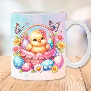 May include: White ceramic mug with a colorful illustration of a yellow chick in a basket with Easter eggs and butterflies. The chick is holding a pink flower.