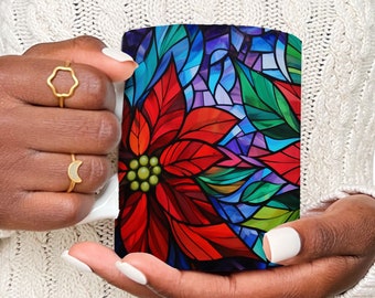 Könnte beinhalten: Eine weiße Keramiktasse mit einem Buntglasdesign einer roten Weihnachtsstern-Blume mit grünen Blättern und blauen, violetten und grünen Akzenten.